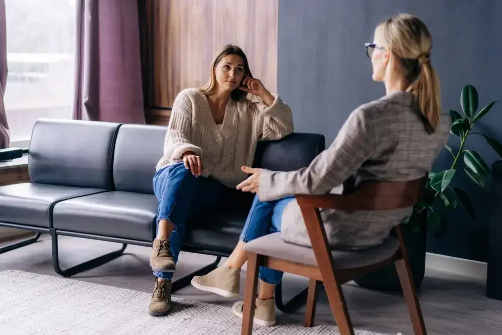 Two women are sitting in a living room having a conversation during individual therapy