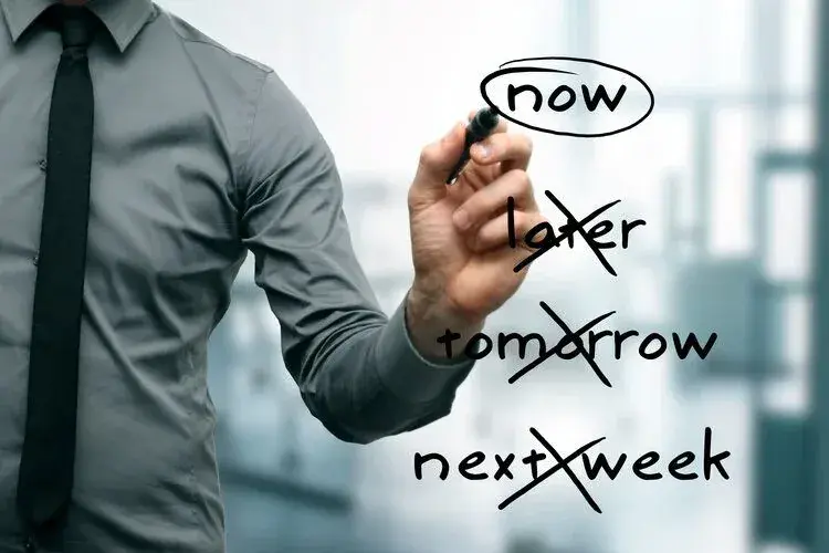 A person circling the word "now" and crossing out "later," "tomorrow," and "next week."