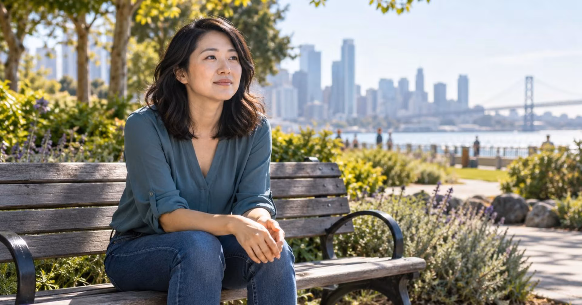 Woman orienting to her surroundings while seated on a sunny park bench.