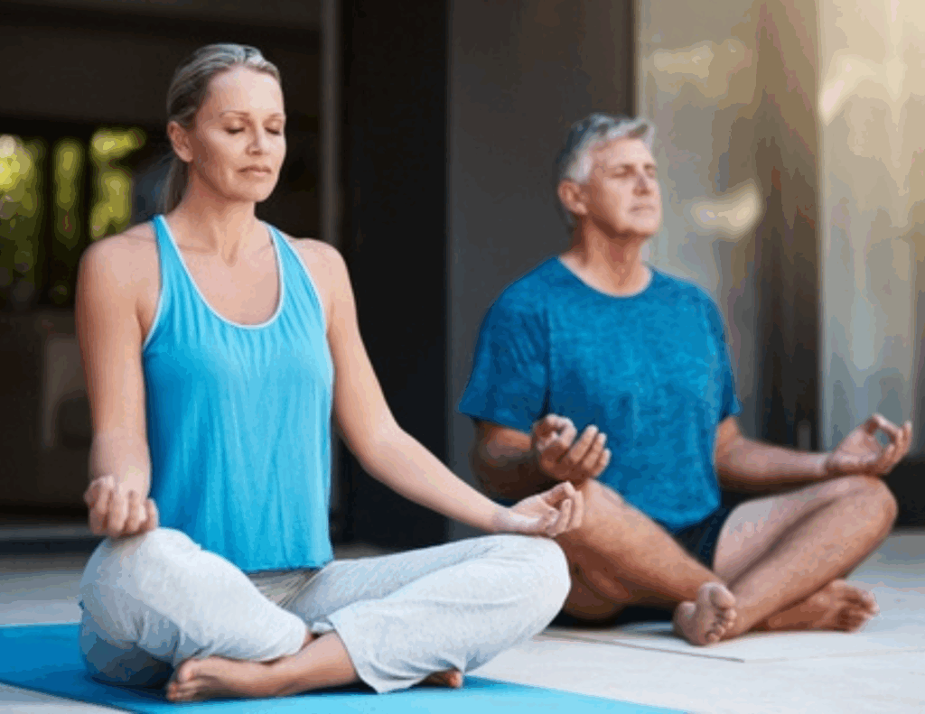 Two adults sit cross-legged on yoga mats, meditating with eyes closed and hands resting on their knees—a serene moment of relationship growth during a personalized couples retreat in a calm indoor space.