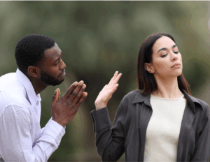 A man with clasped hands appears to plead with a woman who turns away and raises her hand dismissively, highlighting the complexities of relationships and the subtlety of dry begging or indirect requests.