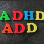 Plastic letters spelling "ADHD" and "ADD" arranged on a dark textured surface, highlighting awareness and treatment options for these conditions.