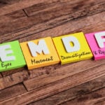 Four colorful sticky notes on a wooden surface spell "EMDR," each labeled: Eyes, Movement, Desensitization, and Reprocessing—a visual representation of EMDR Therapy, a popular trauma treatment also offered by Bay Area CBT specialists.