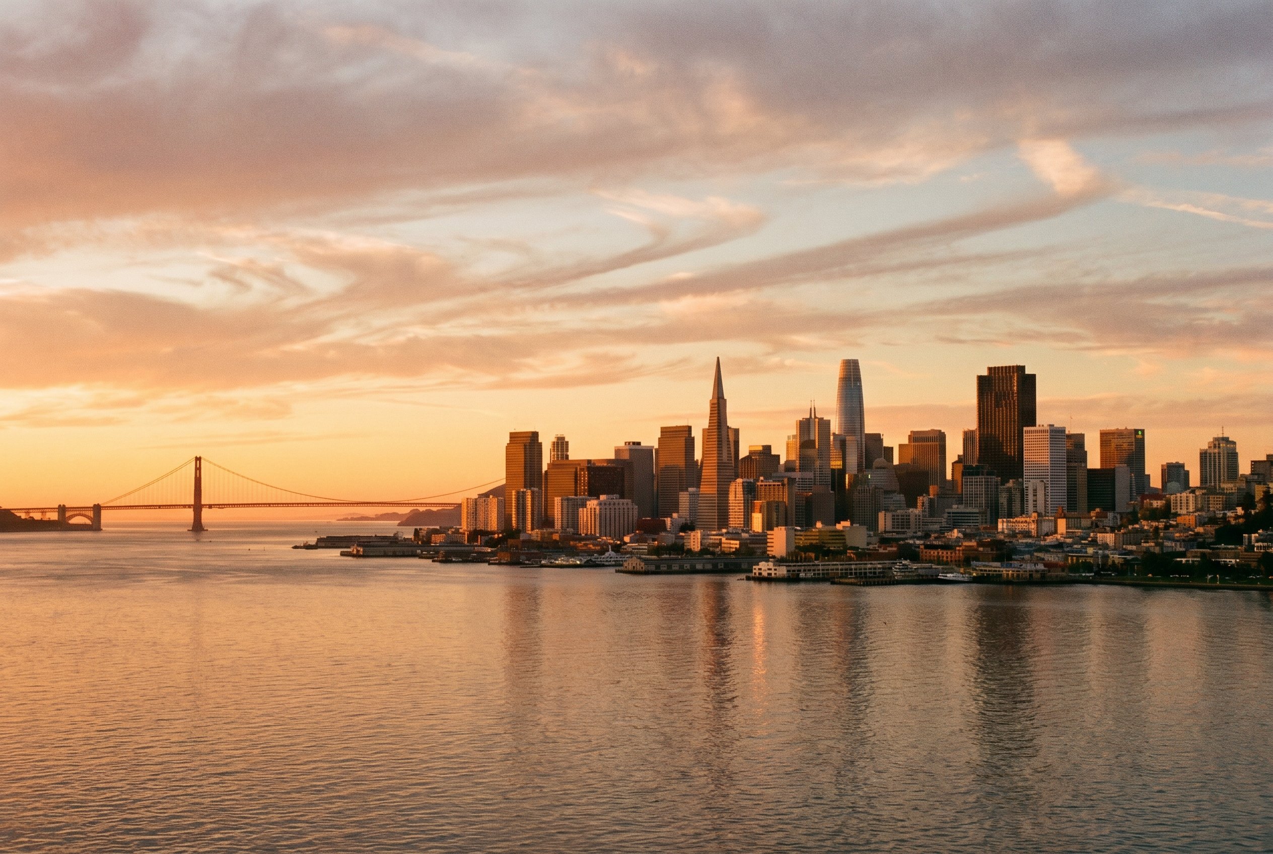 The image depicts a serene San Francisco skyline at sunset, with the calm waters of the bay reflecting the vibrant colors of the sky. This peaceful scene symbolizes the healing journey often sought through therapies like EMDR therapy, which can help individuals process traumatic memories and emotional distress.
